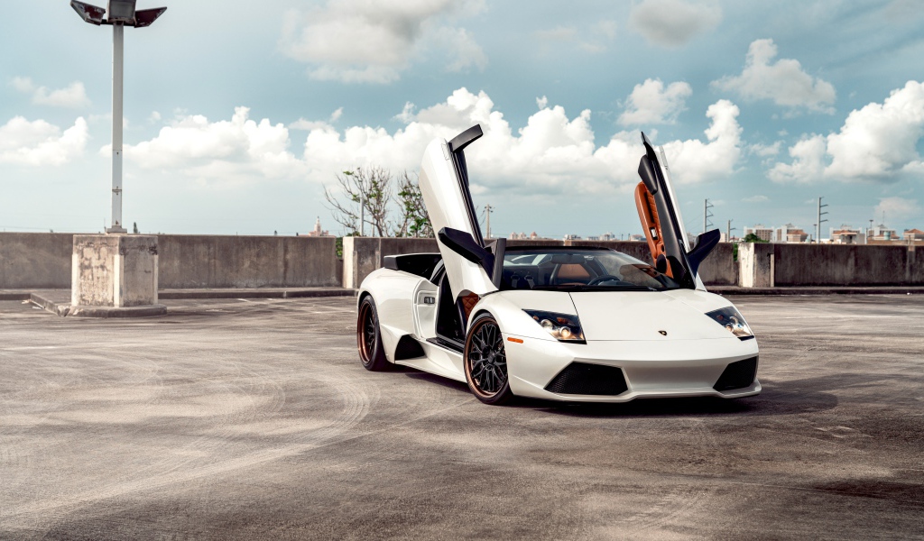 Белый автомобиль Lamborghini Murcielago с открытыми дверями
