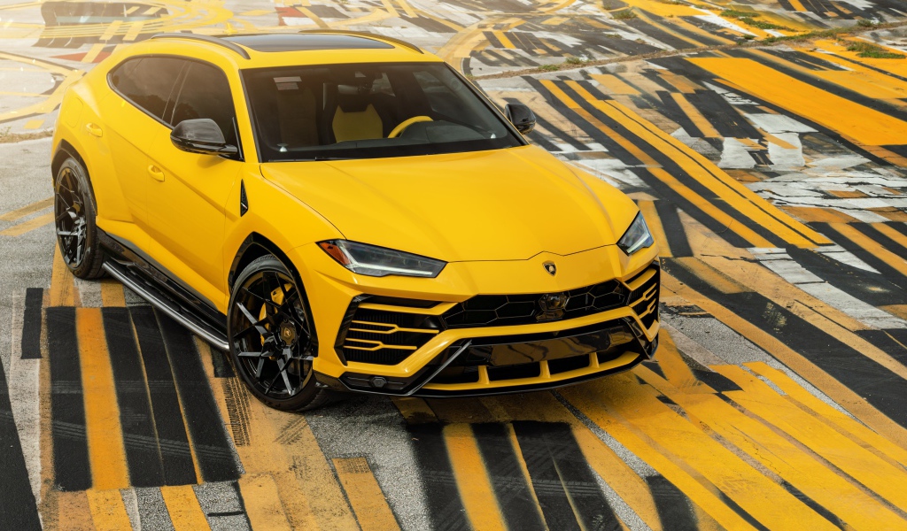 Желтый внедорожник Lamborghini Urus на разноцветном асфальте 