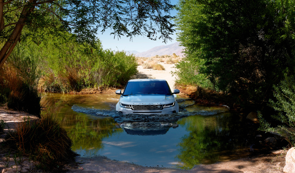 Белый внедорожник Range Rover Evoque едет по воде 