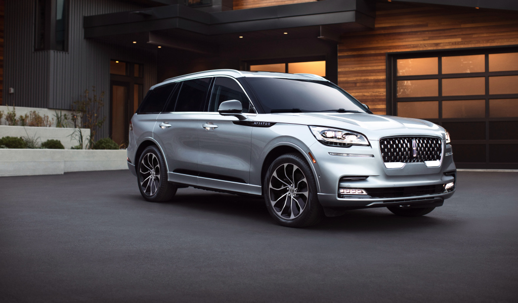 Серебристый внедорожник Lincoln Aviator Grand Touring, 2020 года на фоне дома