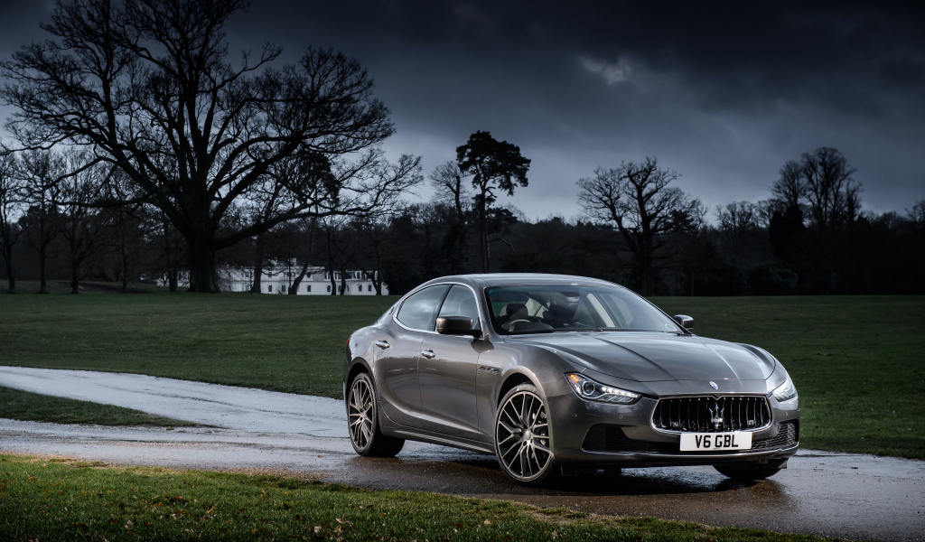 Серебристый автомобиль Maserati Ghibli на фоне грозового неба