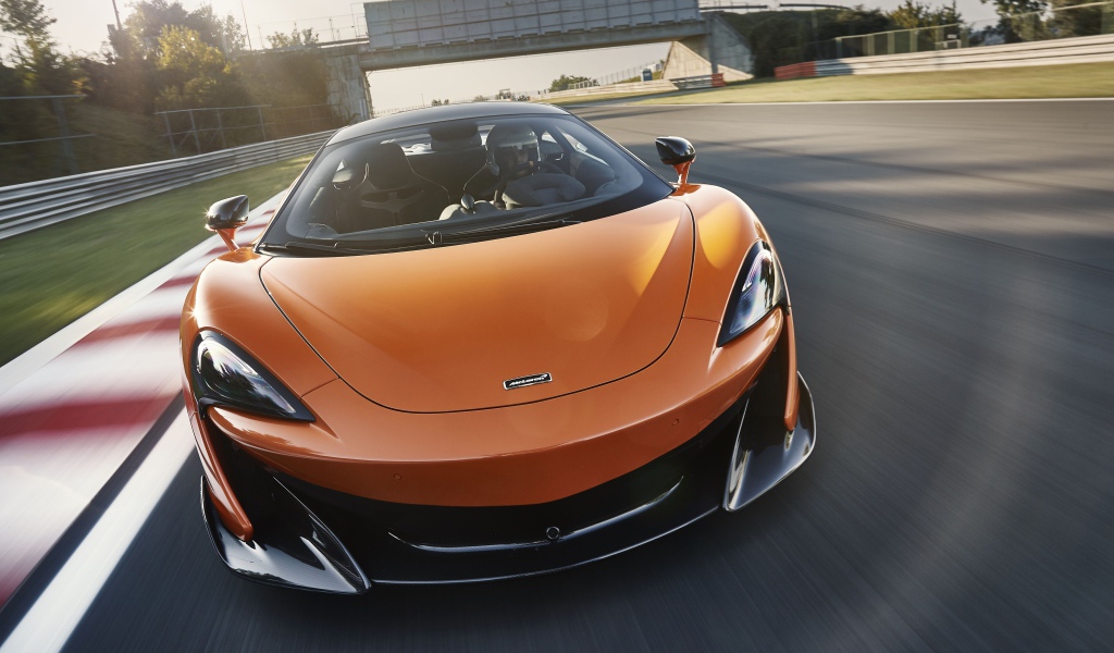 Спортивный оранжевый автомобиль McLaren 600LT 2019 года на трассе