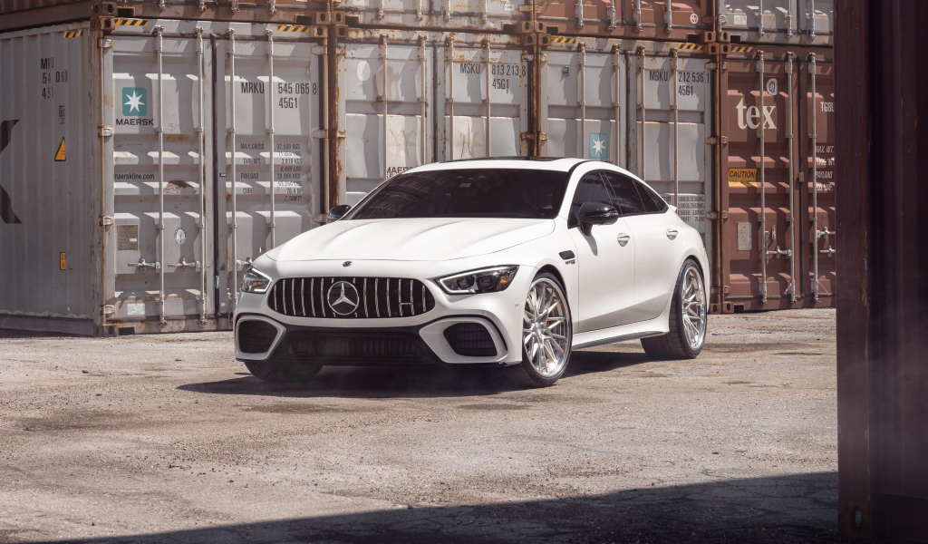 Белый автомобиль Mercedes-AMG GT 63 S стоит у контейнеров