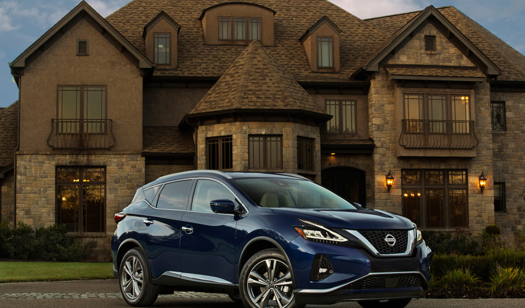 Синий автомобиль Nissan Murano на фоне особняка