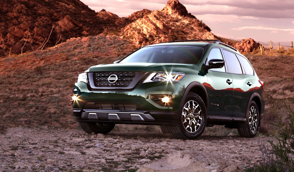 Зеленый автомобиль Nissan Pathfinder в горах 