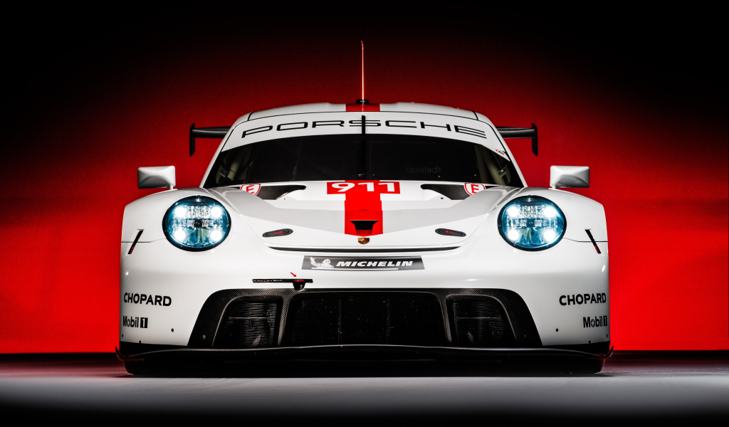 Спортивный автомобиль Porsche 911 RSR 2019 года на красном фоне