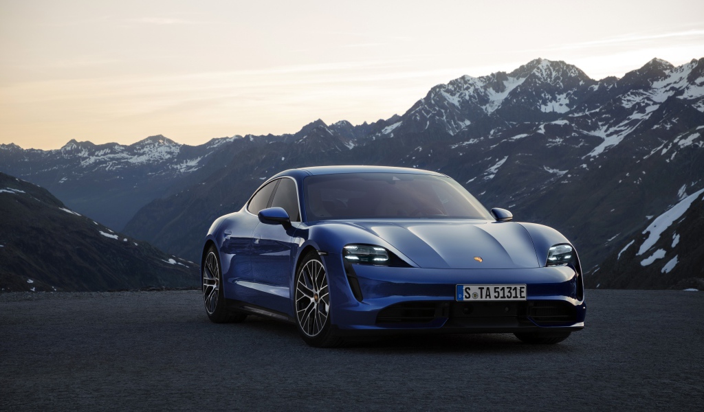 Синий стильный автомобиль Porsche Taycan Turbo 2019 года на фоне гор