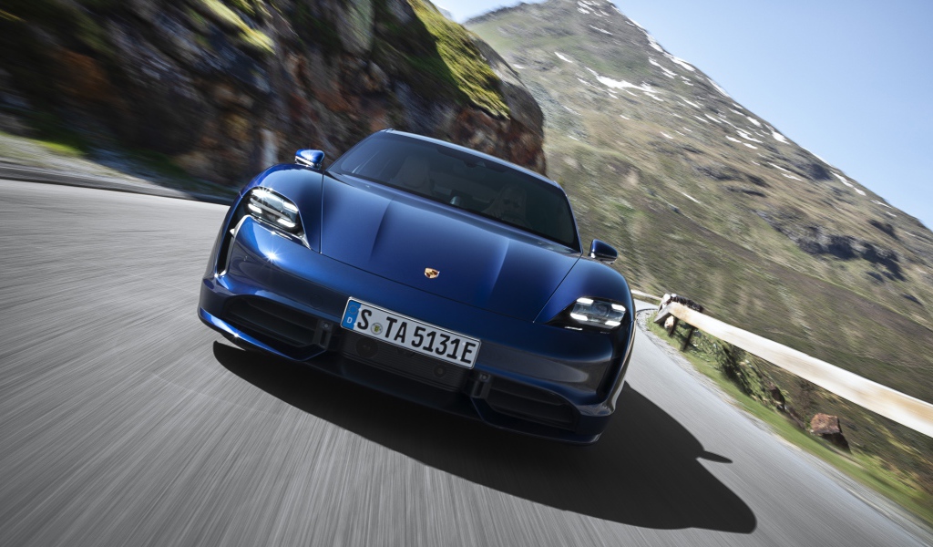 Синий автомобиль Porsche Taycan Turbo 2019 года на фоне гор