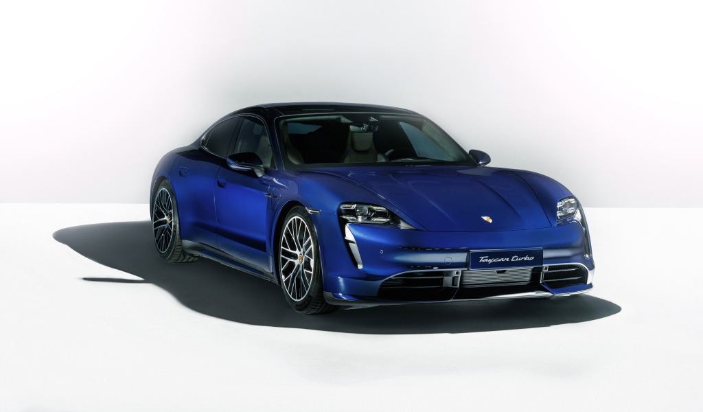 Синий автомобиль Porsche Taycan Turbo 2019 года на сером фоне