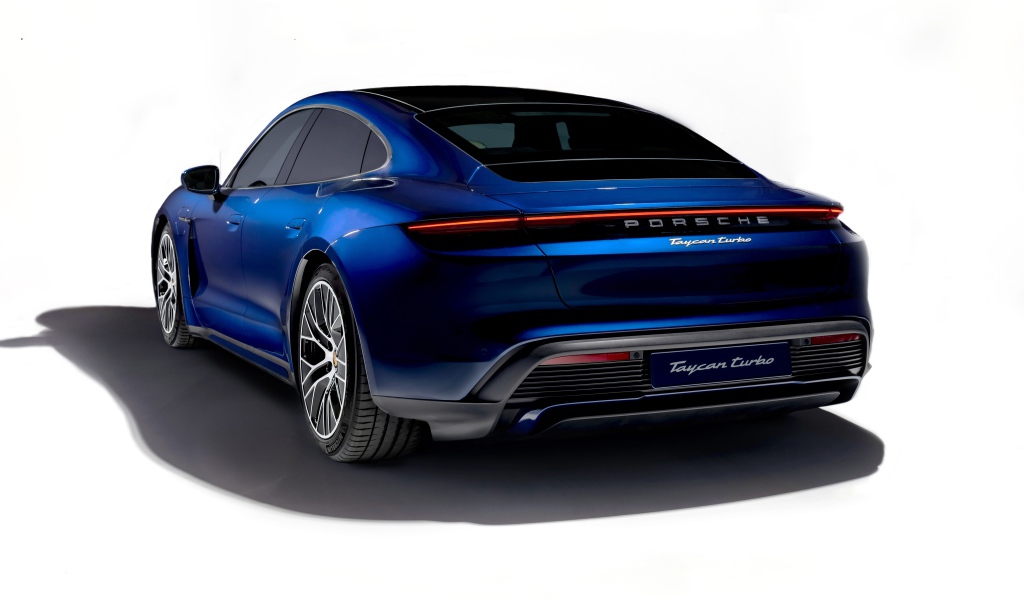 Синий автомобиль Porsche Taycan Turbo 2019 года на белом фоне