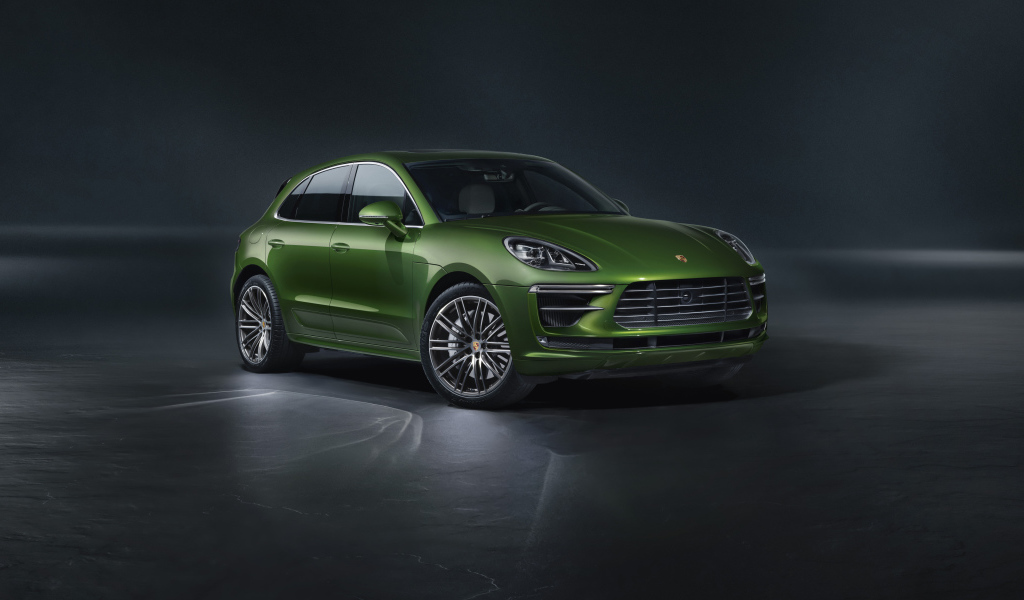 Зеленый автомобиль Porsche Macan Turbo 2019 года на сером фоне