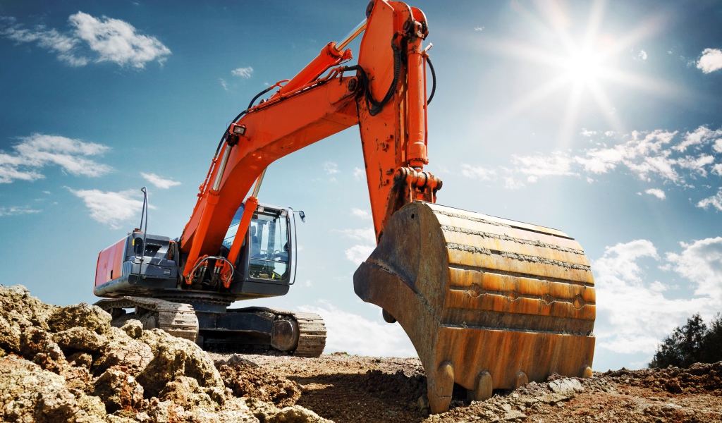 Экскаватор с ковшом на фоне голубого неба