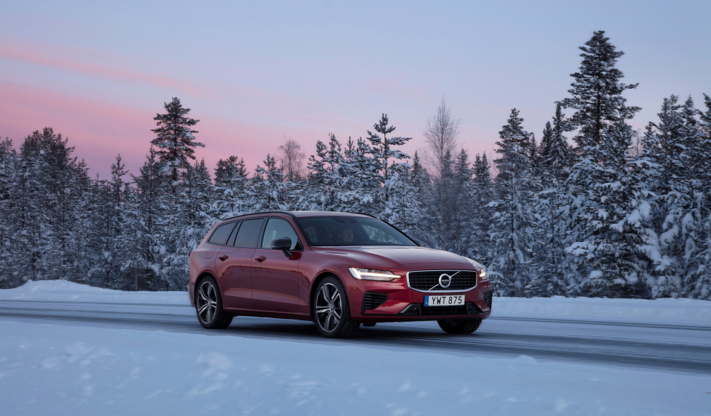 Красный автомобиль Volvo V60 на зимней дороге