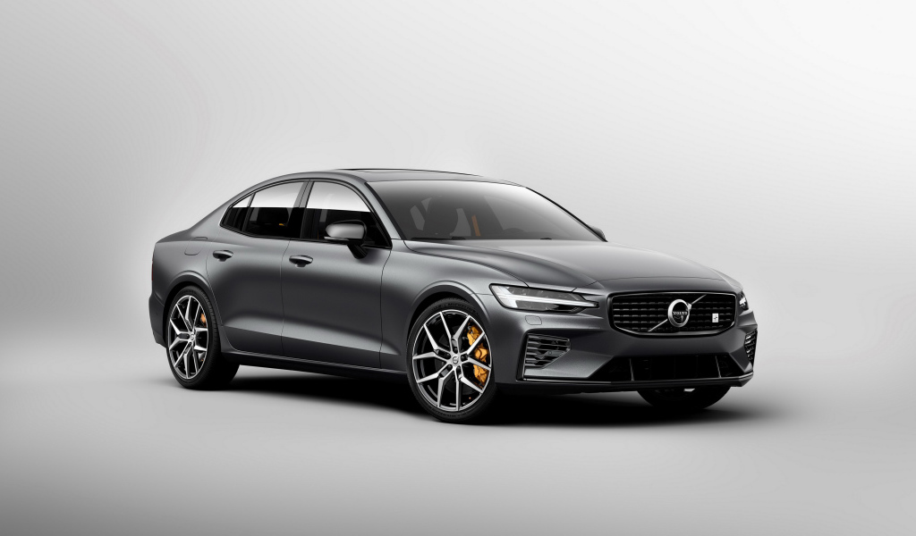 Серебристый автомобиль Volvo S60, 2018 года на сером фоне