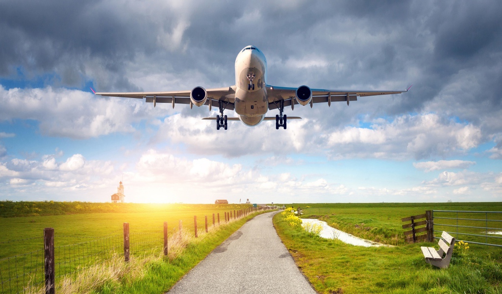 Пассажирский самолет взлетает над полем 