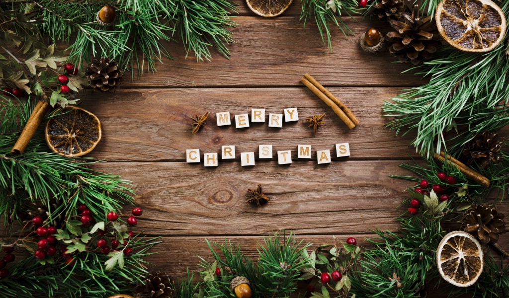 Надпись Merry Christmas на деревянном столе с еловыми ветками 