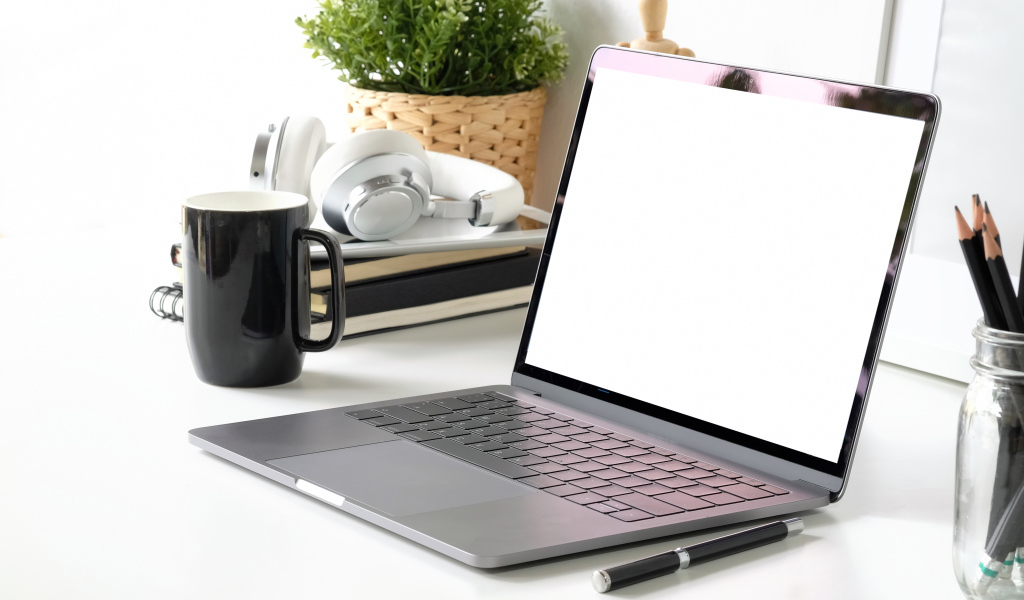 Ноутбук на рабочем столе с чашкой 