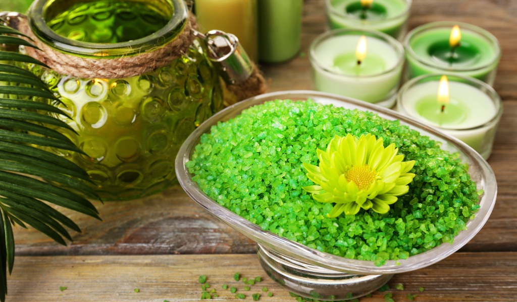Зеленая ароматная морская соль на столе с зажженными свечами