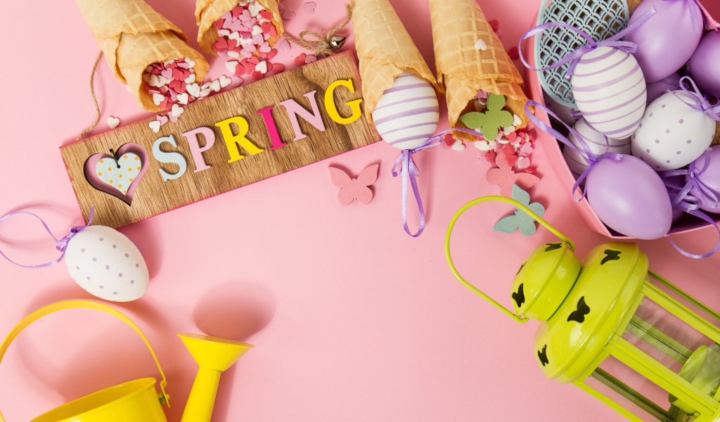 Надпись весна с вафельными рожками и яйцами на розовом фоне