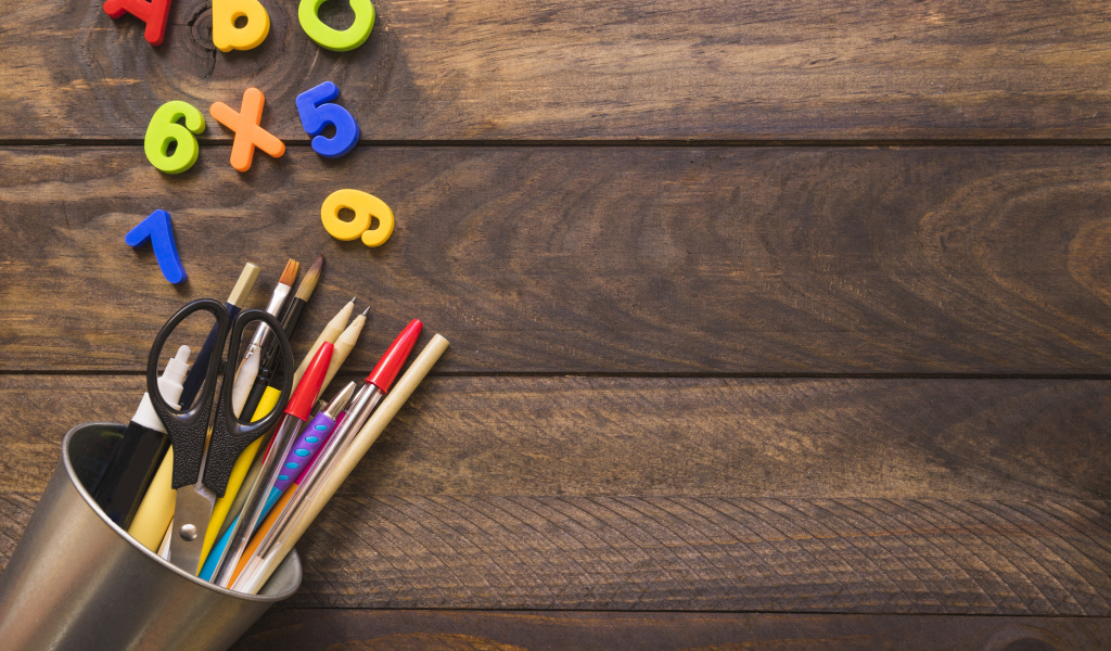 Банка с канцелярскими принадлежностями на деревянном столе с цифрами