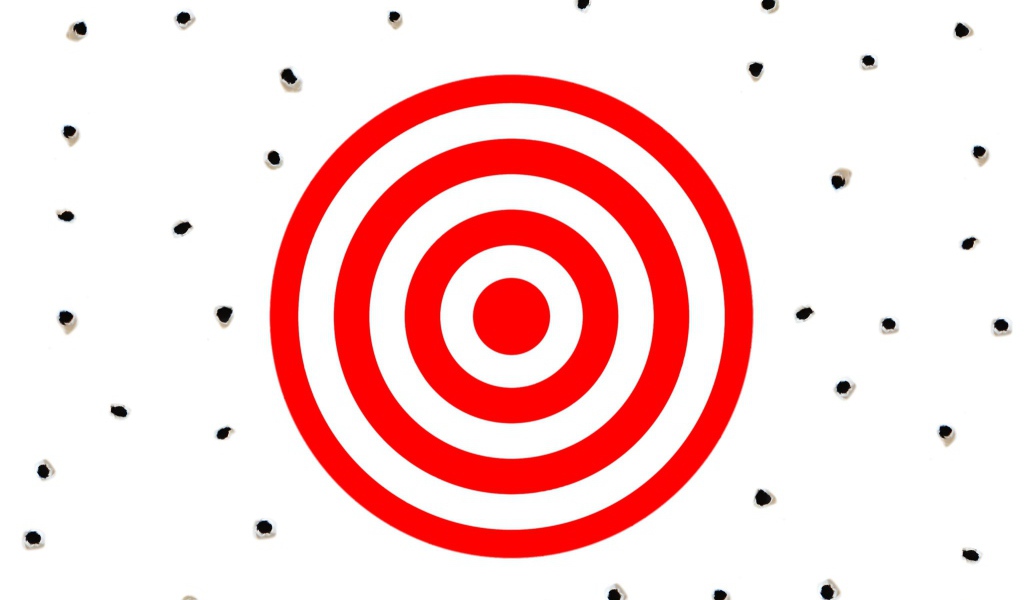 Красная мишень на белом фоне с дырками от пуль