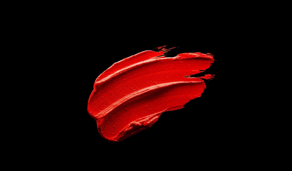 Мазок красной краски на черном фоне