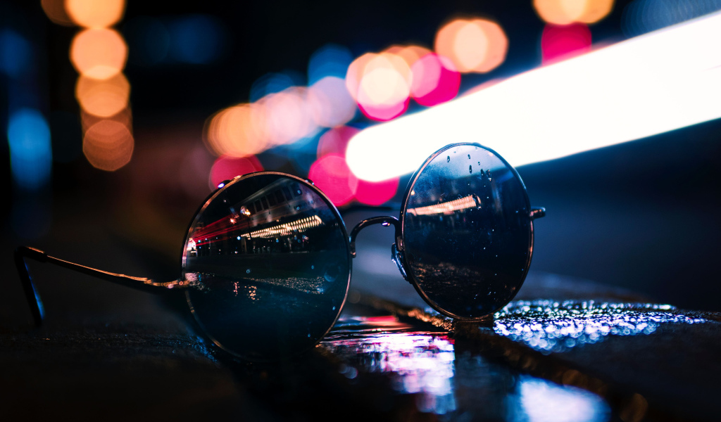 Солнцезащитные очки лежат на мокром асфальте