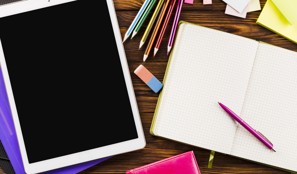 Планшет на столе с блокнотом и карандашами