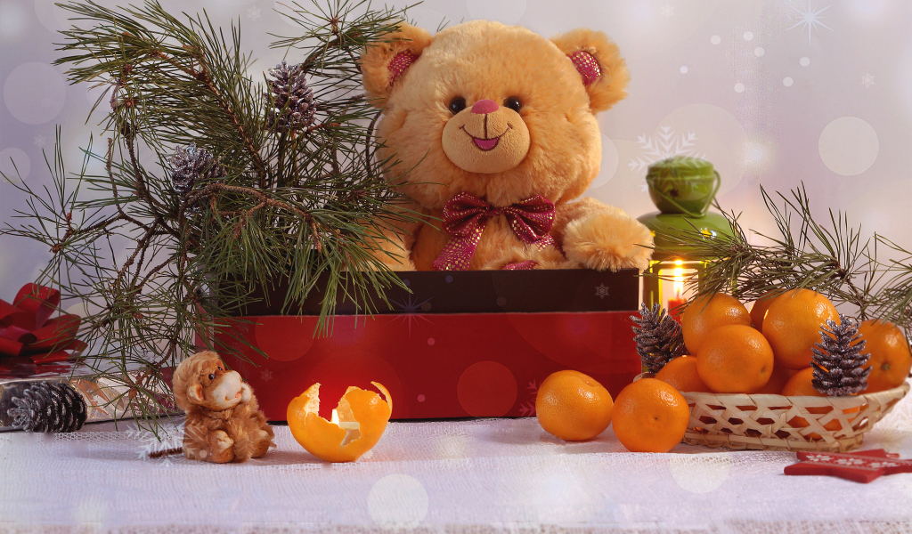 Медвежонок Тедди в коробке с еловой веткой на столе с мандаринами 