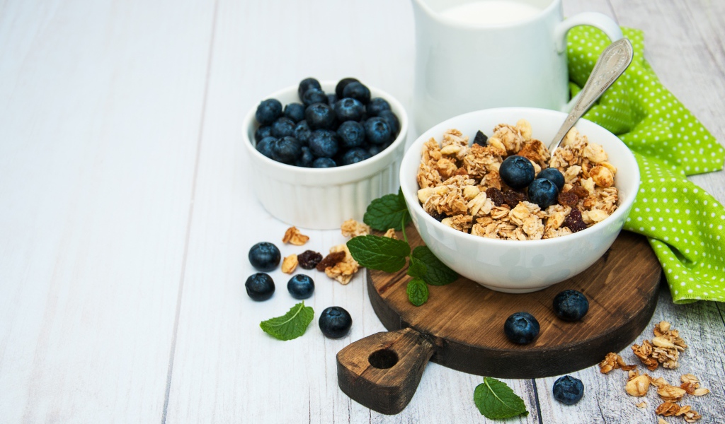 Хлопья с ягодами черники на столе с молоком