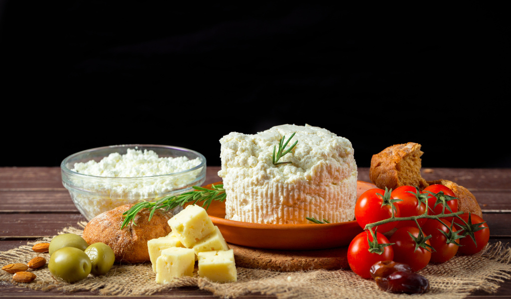 Творог на столе с сыром, хлебом и помидорами