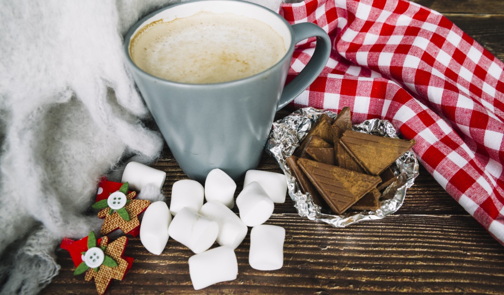 Чашка кофе на столе с маршмеллоу и шоколадом