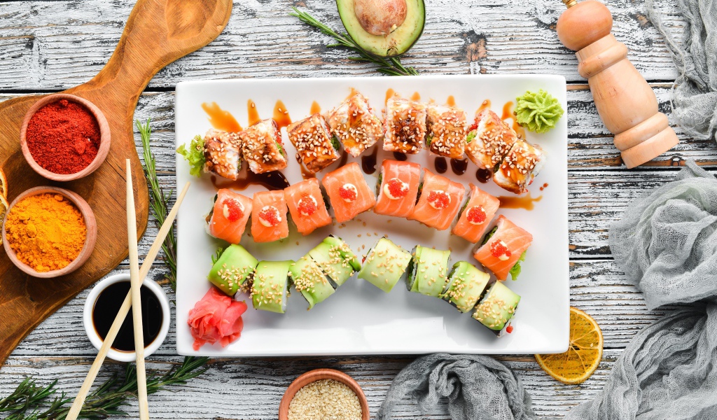 Вкусные аппетитные японские роллы на столе с соусом и специями