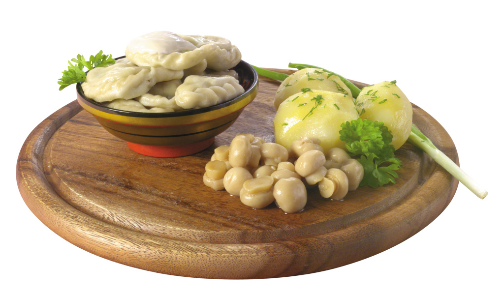 Вареники с грибами и вареной картошкой на деревянной доске на белом фоне