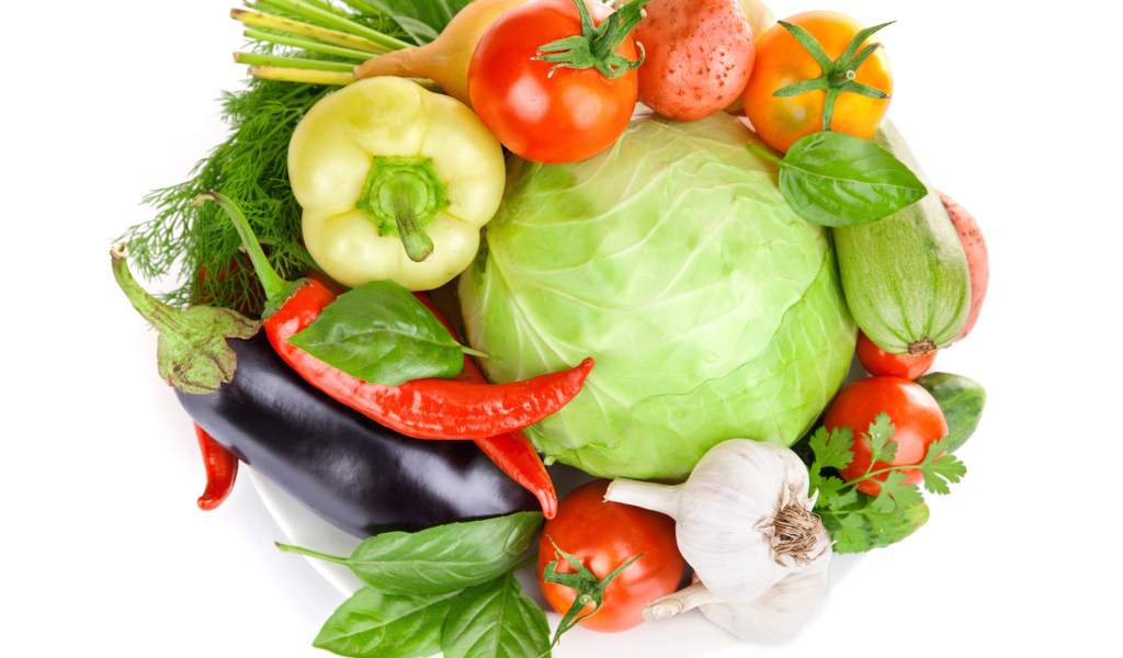 Свежие овощи на белом фоне с зеленью 