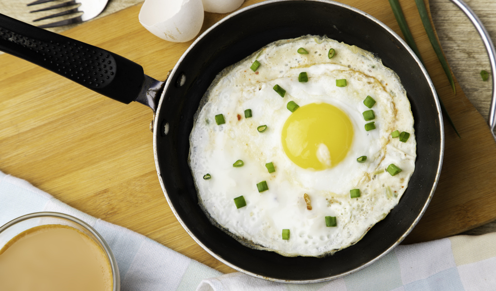Яичница глазунья на сковороде с зеленым луком