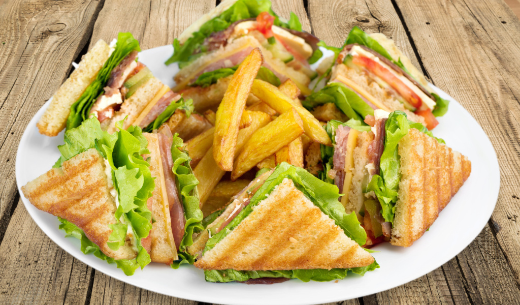 Сэндвичи с ветчиной на тарелке с картофелем фри 