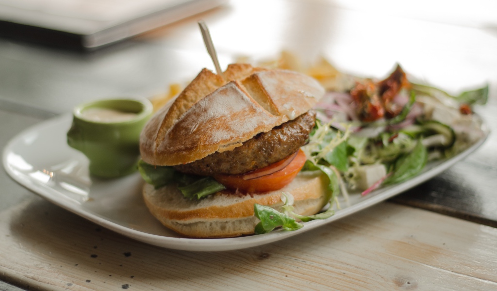 Гамбургер на тарелке с салатом 