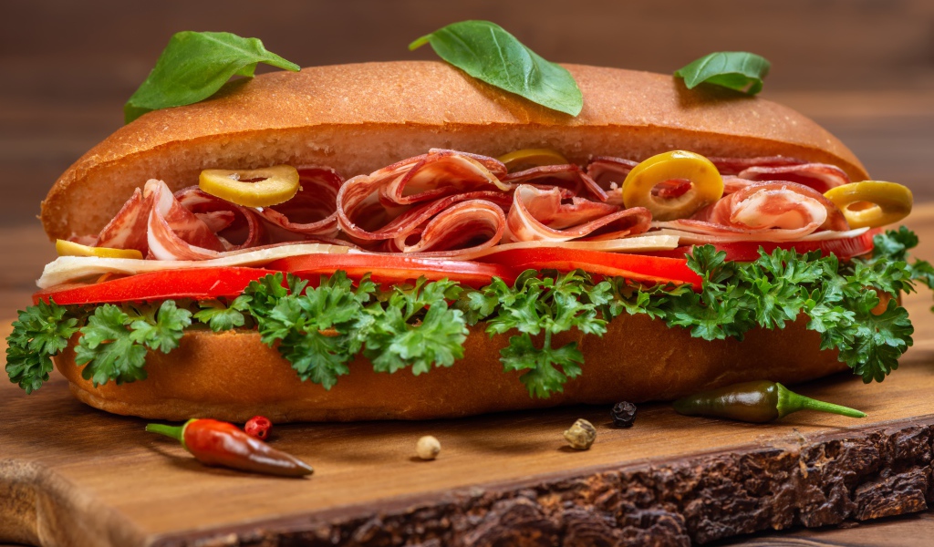 Хот дог с ветчиной, помидорами и листьями петрушки