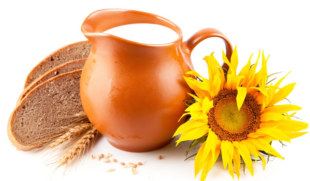 Кувшин с молоком на белом фоне с хлебом и подсолнухом