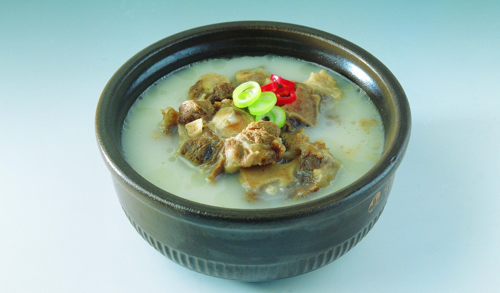 Тарелка супа с говядиной  на голубом фоне