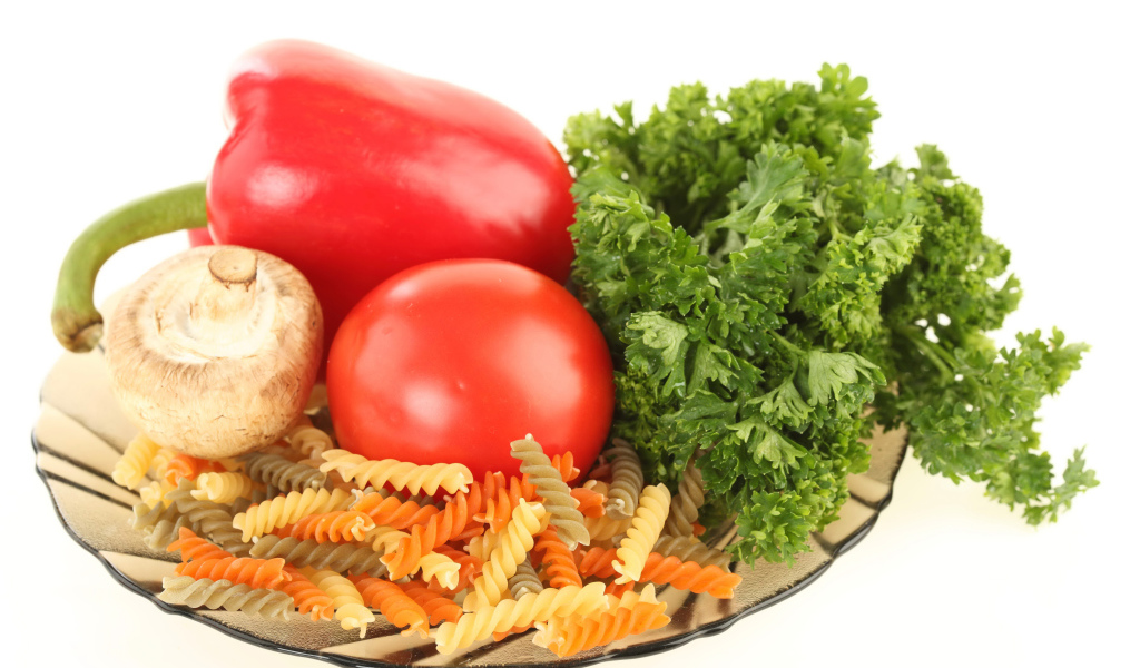 Тарелка с макаронами, красным перцем, помидором, шампиньоном и зеленью петрушки