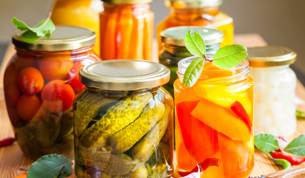 Консервация в стеклянных банках на столе со специями