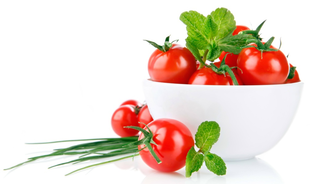 Красные помидоры с зеленым луком на белом фоне
