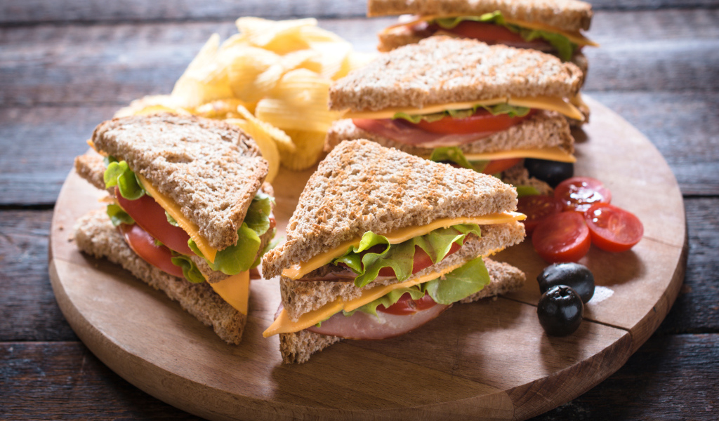 Сэндвичи на деревянной доске с оливками