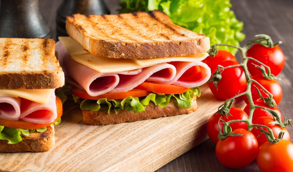 Бутерброды на столе с помидорами и листьями салата