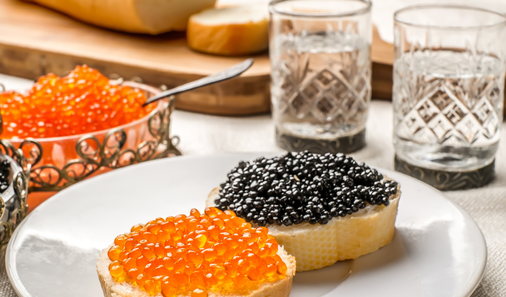 Бутерброды с красной и черной икрой на столе с водкой