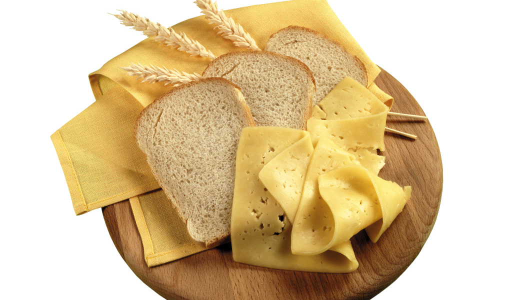 Куски хлеба на разделочной доске с сыром 