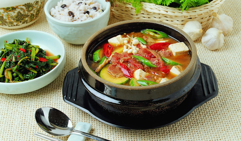 Суп с овощами и мясом на столе с закусками 