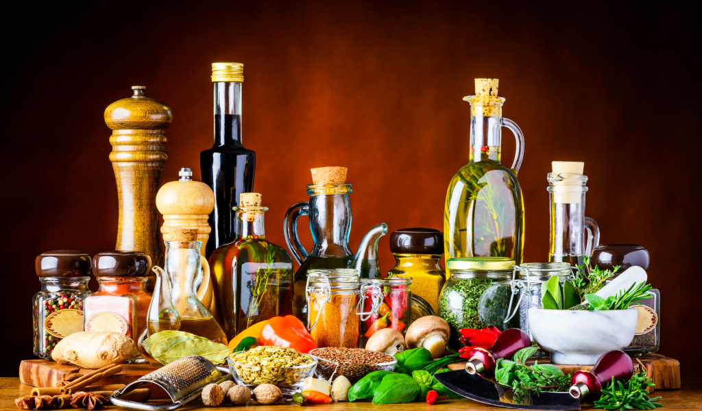 Специи, зелень и масла на столе 